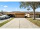 Exterior shot of home with attached two car garage with long driveway and well maintained lawn at 9025 Savannah Julip Ln, Orlando, FL 32832
