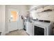 Bright laundry room with new appliances, tile flooring and wire shelving for ample storage space at 9025 Savannah Julip Ln, Orlando, FL 32832