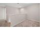 A neutral-colored loft with plush carpeting, a short decorative wall, and stairs to another level at 9025 Savannah Julip Ln, Orlando, FL 32832