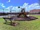 Community playground with a slide, bench, and basketball court surrounded by a black fence at 9025 Savannah Julip Ln, Orlando, FL 32832