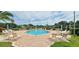 Inviting community pool with lounge chairs and brick patio at 940 Village Trl # 8-101, Port Orange, FL 32127