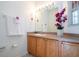 Clean bathroom with wood cabinets, a large mirror, and decorative accents at 1065 Park Ridge Cir, Kissimmee, FL 34746