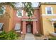 Two-story townhome with a peach-colored exterior, white shutters, and a walkway at 1065 Park Ridge Cir, Kissimmee, FL 34746