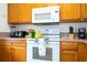 Kitchen features wood cabinets, white appliances, and a breakfast bar at 1065 Park Ridge Cir, Kissimmee, FL 34746