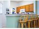 Kitchen with wood cabinets, light countertops, and bar seating at 1065 Park Ridge Cir, Kissimmee, FL 34746