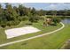 Sand volleyball court and playground by a lake at 1065 Park Ridge Cir, Kissimmee, FL 34746