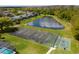 Aerial view of a tennis and basketball court near a lake at 1065 Park Ridge Cir, Kissimmee, FL 34746