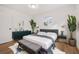 Bright bedroom with a plush bed, dresser, and large plants at 128 Academy Ave, Sanford, FL 32771