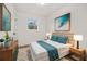 Cozy bedroom featuring a bed with teal bedding and wood nightstands at 128 Academy Ave, Sanford, FL 32771