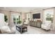 Spacious living room with gray sofa, two armchairs, and sliding glass doors to a patio at 1696 Andover Ridge Dr, Deland, FL 32720
