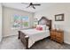 Bedroom with a wooden bed frame, carpeted floors, and two windows at 394 Singing Tree Ln, Winter Springs, FL 32708