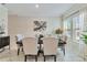 Formal dining room with a dark wood table, neutral chairs, and large windows at 394 Singing Tree Ln, Winter Springs, FL 32708