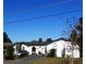 White single-story home with a gray driveway and mature landscaping at 547 Queens Mirror Cir, Casselberry, FL 32707