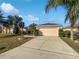 Tan house with a two-car garage and palm trees at 7207 Summit Pl, Winter Haven, FL 33884