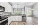 Spacious kitchen area with stainless steel dishwasher and breakfast bar that opens to the living room at 7613 Debeaubien Dr, Orlando, FL 32835