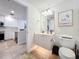 White bathroom with toilet and vanity; kitchen view at 8451 Leatherleaf Ln, Orlando, FL 32827
