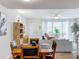 Bright dining room with a wooden table and chairs, overlooking the living room at 8451 Leatherleaf Ln, Orlando, FL 32827
