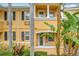 Close-up of two-story townhome entrance, featuring yellow painted walls and lush landscaping at 8451 Leatherleaf Ln, Orlando, FL 32827