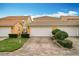 Front view of townhouses with garages and well-maintained landscaping at 8451 Leatherleaf Ln, Orlando, FL 32827