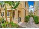 Side entrance to a two story townhome with a walkway, landscaping, and palm trees at 8451 Leatherleaf Ln, Orlando, FL 32827