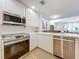 Open concept kitchen with stainless steel appliances and white cabinets at 8451 Leatherleaf Ln, Orlando, FL 32827