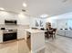 Open concept kitchen with stainless steel appliances and white cabinets at 8451 Leatherleaf Ln, Orlando, FL 32827