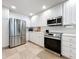 Modern kitchen with stainless steel appliances and white cabinets at 8451 Leatherleaf Ln, Orlando, FL 32827