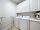 Laundry room with washer, dryer, cabinets, and drying rack at 8451 Leatherleaf Ln, Orlando, FL 32827