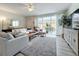 Spacious living area featuring a plush sofa, sliding glass doors, and a large TV at 8451 Leatherleaf Ln, Orlando, FL 32827