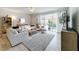 Bright living room with comfy seating, large windows, and access to a patio at 8451 Leatherleaf Ln, Orlando, FL 32827