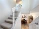 Carpeted staircase with white railing and dining room view at 8451 Leatherleaf Ln, Orlando, FL 32827