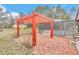 Backyard with a red pergola, seating, and a screened in pool at 8520 Sw 209Th Ct, Dunnellon, FL 34431