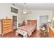 Cozy bedroom featuring wood floors, ceiling fan, and a comfortable seating area at 8520 Sw 209Th Ct, Dunnellon, FL 34431