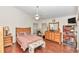 Comfortable main bedroom featuring wood flooring, ceiling fan, and a dresser with a mirror at 8520 Sw 209Th Ct, Dunnellon, FL 34431