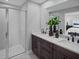 Double vanity bathroom with dark brown cabinets and gray tile shower at 9847 Walkway Dr, Orlando, FL 32832