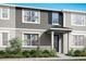 Two-story townhome with gray siding, blue shutters, and landscaping at 9851 Walkway Dr, Orlando, FL 32832