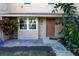 Front entrance of a tan house with a brown door and landscaping at 1009 Grove St # 90, Maitland, FL 32751