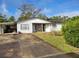 White brick ranch house with a carport and mature landscaping at 1070 N Libby Ct, Daytona Beach, FL 32117