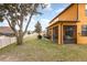 Backyard view of house with large tree and screened patio at 10820 Wyandotte Dr, Clermont, FL 34711