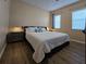 Spacious bedroom with a queen-size bed and wood floors at 12021 Villanova Dr # 111, Orlando, FL 32837