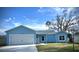 Charming light blue single-story home with a well-maintained lawn and two car garage at 1334 Dean Ave, Eustis, FL 32726