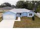 Newly constructed light blue house with a white garage door and landscaped front yard at 1334 Dean Ave, Eustis, FL 32726