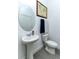 Small powder room with pedestal sink, toilet, and framed world map at 13384 Leggett Aly, Orlando, FL 32827