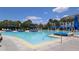 Large pool with blue umbrellas and lounge chairs at 13384 Leggett Aly, Orlando, FL 32827