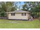 Tan house with a side yard, and trees surrounding the property at 2404 Chase Ave, Sanford, FL 32771