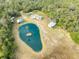 Aerial view of property with a pond, multiple buildings, and lush vegetation at 2570 Canvasback Trl, Geneva, FL 32732