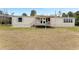 Tan single-story home with deck and a spacious lawn at 2570 Canvasback Trl, Geneva, FL 32732