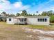 Exterior view of a single-story manufactured home with a deck and covered porch at 2570 Canvasback Trl, Geneva, FL 32732