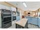 Modern kitchen with blue cabinets, island, and stainless steel appliances at 2570 Canvasback Trl, Geneva, FL 32732