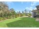 Spacious backyard with covered patio, lush landscaping, and expansive lawn at 2647 Zuni Rd, St Cloud, FL 34771